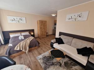 1 dormitorio con 1 cama y 1 sofá en ApartHouse Apartamenty Centrum, en Katowice