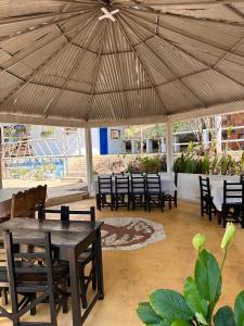 a group of tables and chairs under a large umbrella at Cabaña-Finca Portal De La Ceiba in San Gil +32 photos
