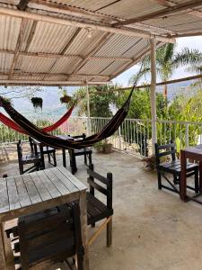 a hammock in a pavilion with tables and benches at Cabaña-Finca Portal De La Ceiba in San Gil