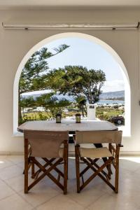 een tafel in een kamer met een groot raam bij House for two!! in Angairiá