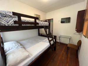 a bedroom with two bunk beds and a tv at La Perla de Cobano in Puntarenas