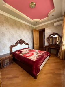 Fireside Fiesta Haven في كوتايسي: غرفة نوم مع سرير مع لحاف احمر
