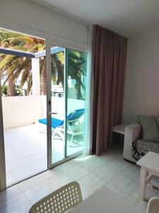 a living room with a sliding glass door to a patio at Alisios Playa, pool view in Corralejo