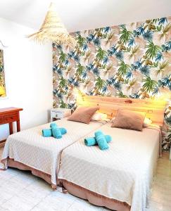 a bedroom with two beds with blue pillows at Alisios Playa, pool view in Corralejo