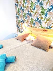 a bedroom with two beds with pillows and a wallpaper at Alisios Playa, pool view in Corralejo