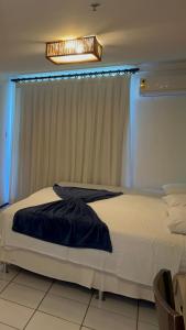 Schlafzimmer mit einem großen weißen Bett und einem Fenster in der Unterkunft Gran Lençóis Flat Barreirinhas in Barreirinhas