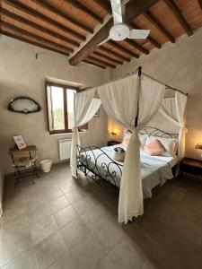 a bedroom with a canopy bed with a ceiling at -- Il Casale Toscano -- 1700mt dalla Torre di Pisa, ONLY RENTS ROOMS WITHOUT BREAKFAST, FREE PARKING, POSSIBILITÀ DI SELF CHECK-IN DALLE 15 in Pisa