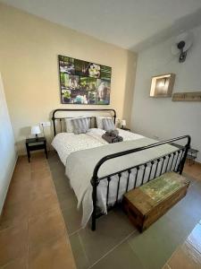 Schlafzimmer mit einem großen Bett und einer Holzkiste in der Unterkunft El bufon de la corte in Carratraca
