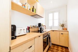 eine Küche mit einer Arbeitsfläche aus Holz und einem Waschbecken in der Unterkunft Luminous cocoon near Paris in Bagnolet