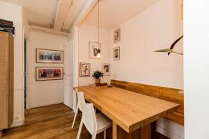 une salle à manger avec une table en bois et des chaises blanches dans l'établissement Luminous cocoon near Paris, à Bagnolet