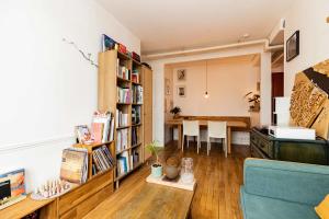 ein Wohnzimmer mit einem Sofa und einem Esszimmer in der Unterkunft Luminous cocoon near Paris in Bagnolet