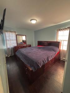 a bedroom with a large bed and a mirror at A little piece of home in Arverne