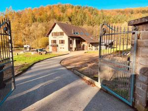 an open gate to a house with a driveway at Maison d'hôtes en forêt avec des chevaux, Domaine du Trèfle d'Or in Soucht