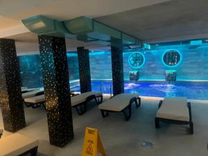 a room with a pool with chairs and a clock at Apartmani K&V in Veliko Gradište