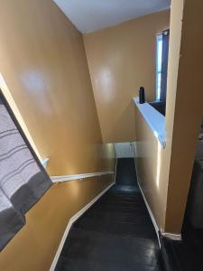 um corredor com uma escada com um lavatório e uma janela em A little piece of home em Arverne