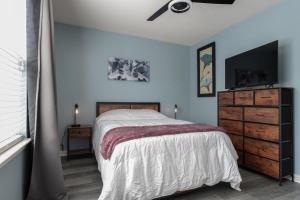um quarto com uma cama e uma cómoda com uma televisão de ecrã plano em The High Point Haven em High Point