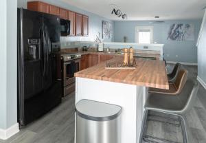 uma cozinha com um frigorífico preto e uma bancada de madeira em The High Point Haven em High Point