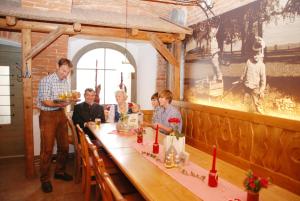 eine Gruppe von Menschen, die an einem Tisch in einem Restaurant sitzen in der Unterkunft Ferienhof Turmkeller in Grieskirchen