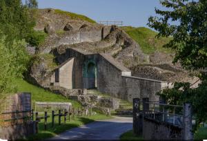 an old stone building on a hill with a road at L appartement chez J&C in Mandeure