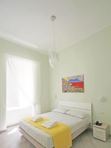 - une chambre blanche avec un lit et un tableau mural dans l'établissement Maison Carolina, à Naples