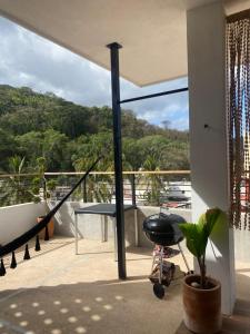 een balkon met een tafel en uitzicht op de bomen bij Penthouse kavali in Los Ayala