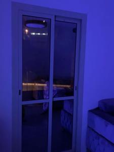 a door in a room with a purple light at ALHNOFF MAKKAH 1 in Aţ Ţunḑubāwī