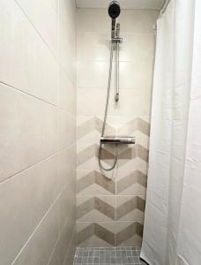 uma casa de banho com chuveiro e cortina de chuveiro em Miegu - Apartments em Druskininkai