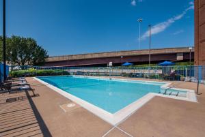 une grande piscine avec des chaises et un bâtiment dans l'établissement Best Western Springfield, à Springfield