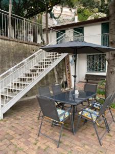 a table and chairs with an umbrella on a patio at La Perla del Mare Apartment Vietri sul Mare in Albori
