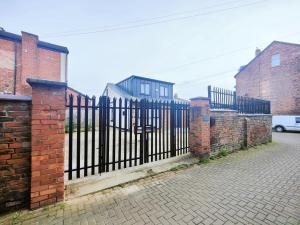 a black wrought iron fence in front of houses at Shaw Heath Cottage - Charming Holiday Home In the Heart of Stockport in Stockport