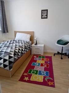 1 dormitorio con cama y alfombra en 48 kingfisher, en Chatham