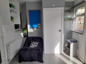 Pokój z krzesłem i białymi drzwiami w obiekcie 48 kingfisher w mieście Chatham