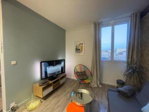 a living room with a tv and a window at Appartement Hyper Centre-Vieux Port-Place aux Huiles in Marseille