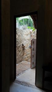 una puerta abierta con vistas a una pared de piedra en Hotel Boutique Aurea en Bacalar