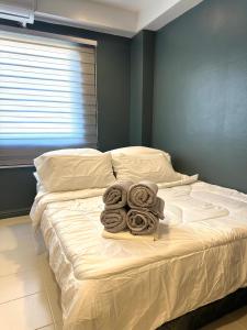CRIB 217 SUBIC BAY - Modern Fresh Condo في اولونجابو: سرير وفوط مطوية عليه في غرفة النوم