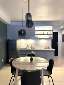 a kitchen with a table and chairs and blue cabinets at CRIB 217 SUBIC BAY - Modern Fresh Condo in Olongapo