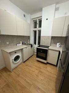 a kitchen with white cabinets and a washing machine at Sailor Apartment by Marina Old Town for 8 people, free parking! in Gdańsk