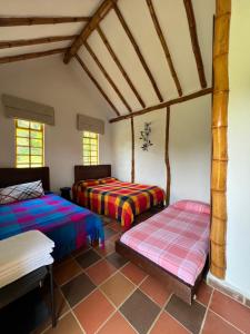 two beds in a room with wooden ceilings at Sinadan in Barbosa