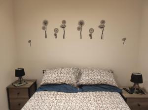 1 dormitorio con 1 cama con dientes de león en la pared en Chez Dori Chambre privée, en Bischheim