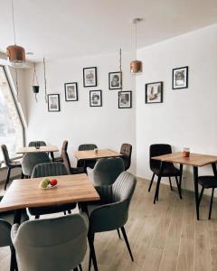 a restaurant with wooden tables and chairs and pictures on the wall at LASKARA Garden Apartment by Prague Forest in Nové Jirny