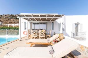 patio con sedie, tavolo e piscina di Ocean Blue Villa by LLB - Beach in 6min walking a Mykonos Città