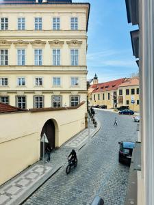 a person riding a motorcycle on a cobblestone street next to a building at Prague Historic Center Apartments in Prague