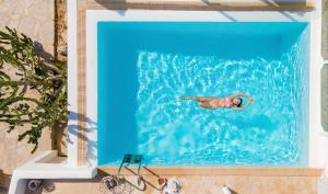 una persona che nuota in acqua in una piscina di Ocean Blue Villa by LLB - Beach in 6min walking a Mykonos Città Altre 69 foto