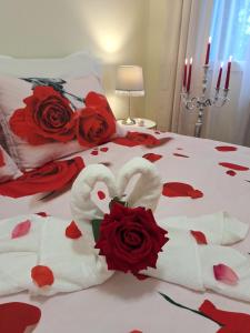 エゲルにあるAlbina apartmanのベッド(タオル、赤いバラ付)