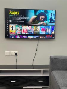 a flat screen tv hanging on a wall at Rejao Homes in Dar es Salaam