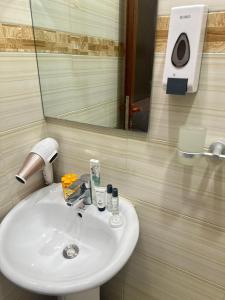 lavabo blanco en el baño con espejo en Rejao Homes en Dar es Salaam