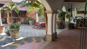 an outdoor patio with potted plants and an archway at Casa Gabriel in Antigua Guatemala