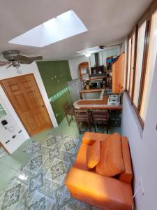 a living room with an orange couch and a kitchen at Casa Gabriel in Antigua Guatemala