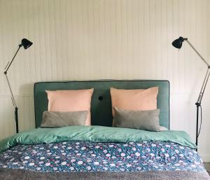 a bedroom with a bed with a green headboard and two lamps at Maison situé au centre d'Enghien les Bains avec jardin et parking privé in Enghien-les-Bains
