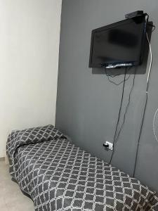a bedroom with a bed and a flat screen tv at Cabañas Autodromo in Termas de Río Hondo
